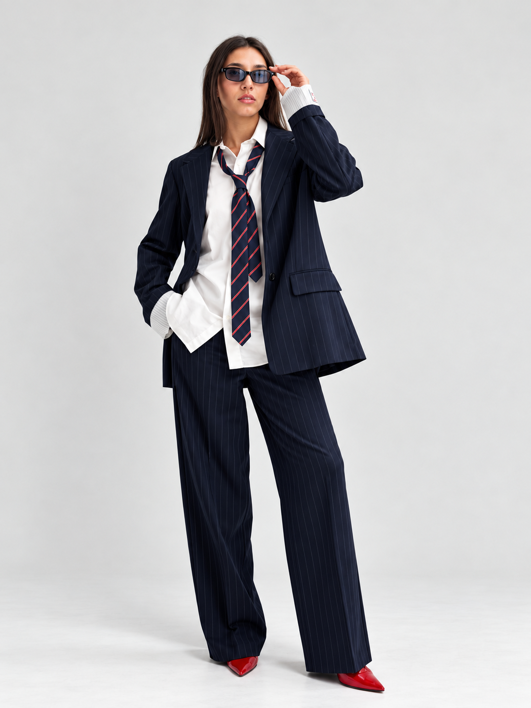 Look donna con completo gessato blu, camicia bianca e scarpe rosse